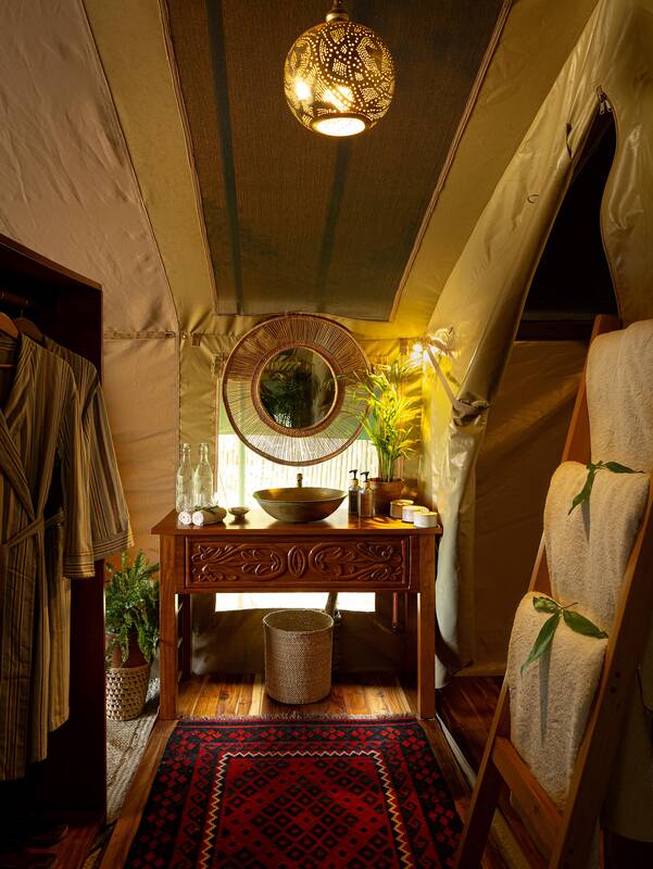 A suite bathroom — carved vanity, basin and round mirror