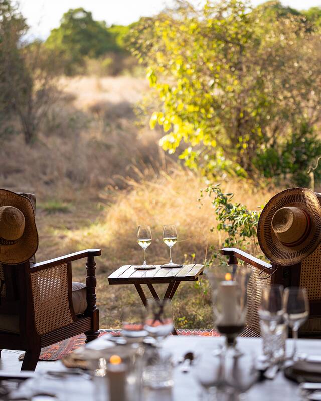 Wine glasses and a safari hat — lunch laid in the shade