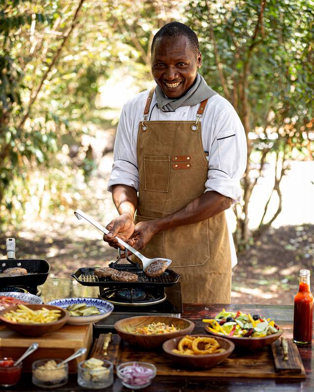 A Seringet chef at the grill, lunch laid out in front of him