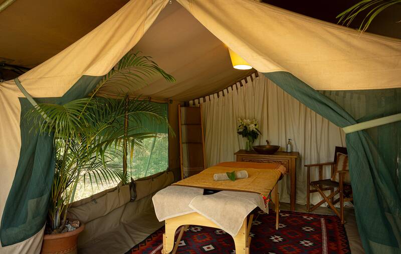 A massage table laid out in a canvas tent