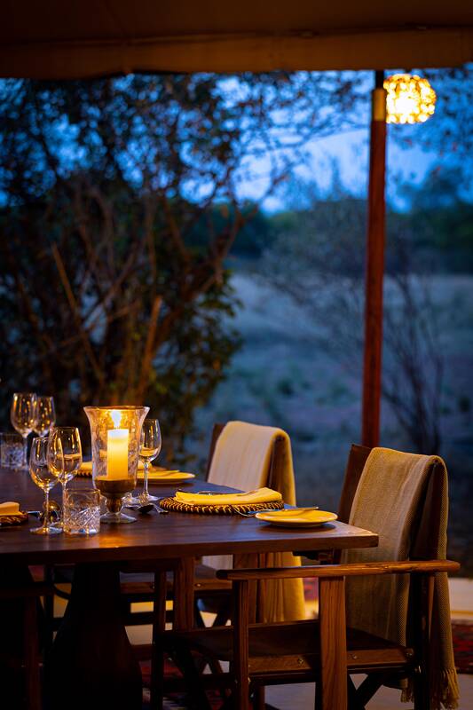 A table set at blue hour beneath a verandah lantern
