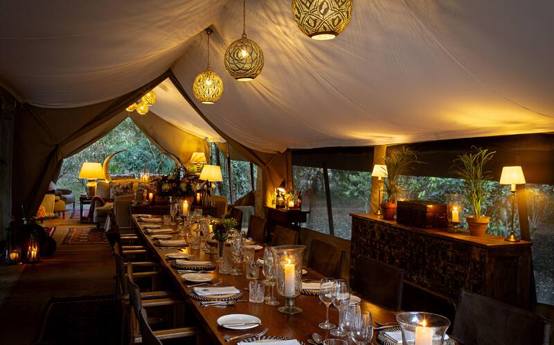The long mess table candlelit for dinner under hanging lanterns