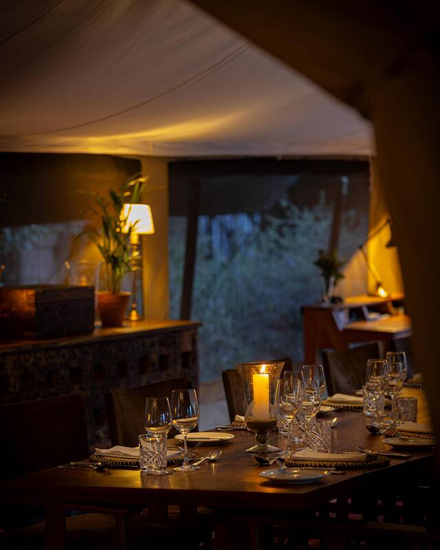 A table laid for dinner by lamplight