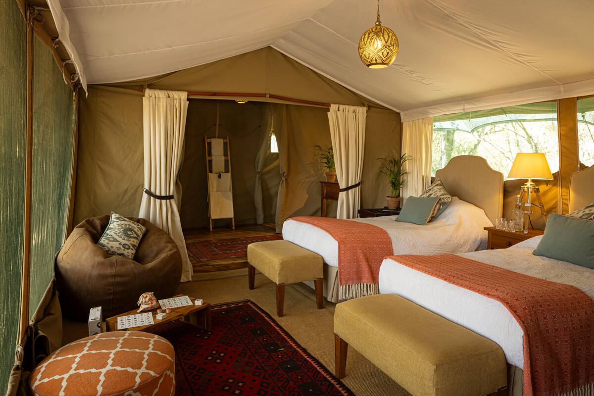 Children's side of a Seringet family tent — twin beds, a beanbag and kilim rugs