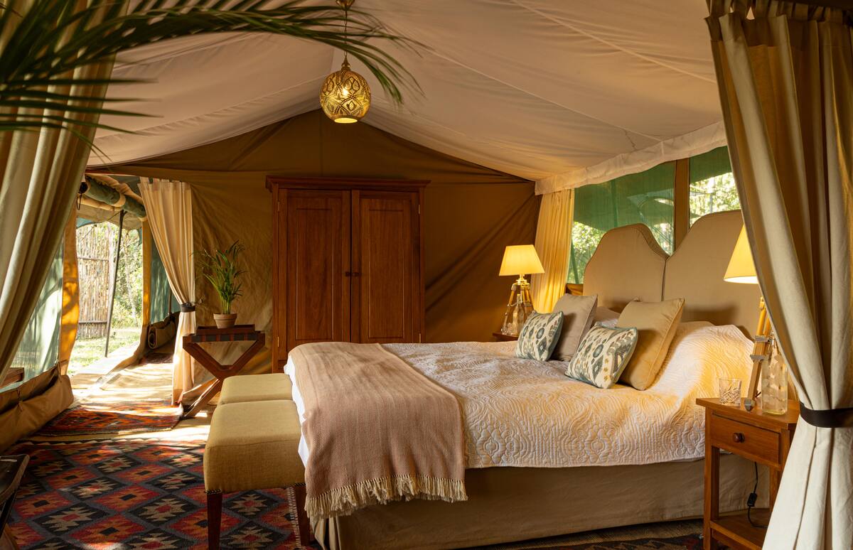 Parents' side of a Seringet family tent — king bed under a brass lantern