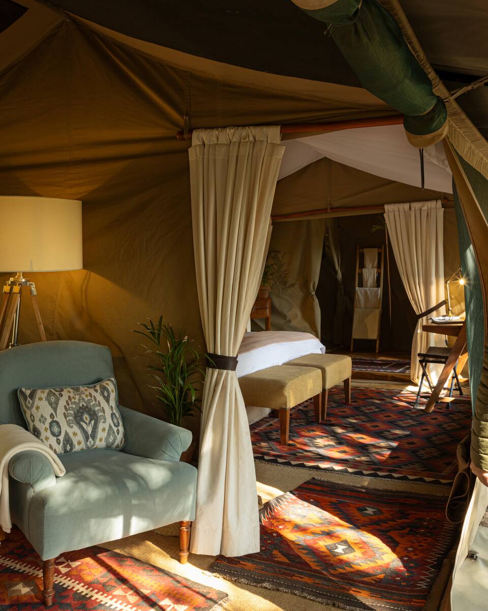 Looking through a family tent from the armchair to the bedroom beyond