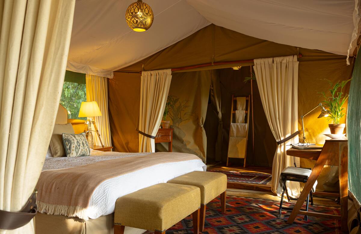 A family-tent bedroom with writing desk, lamp and kilim rugs