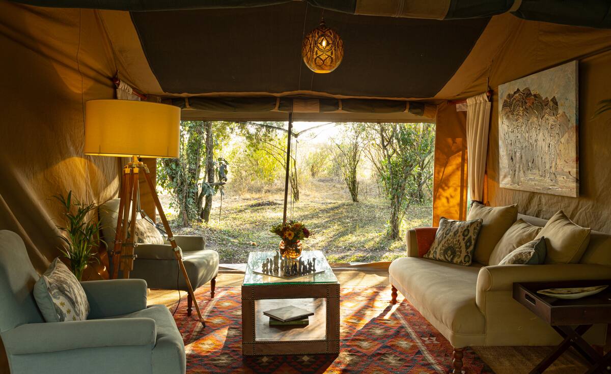 The family tent sitting room, sofas and a coffee table open to the bush