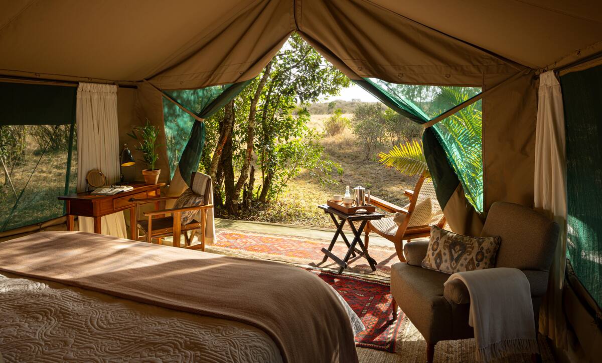 A Seringet suite — bed, armchair and writing desk, the tent open onto its verandah and the bush
