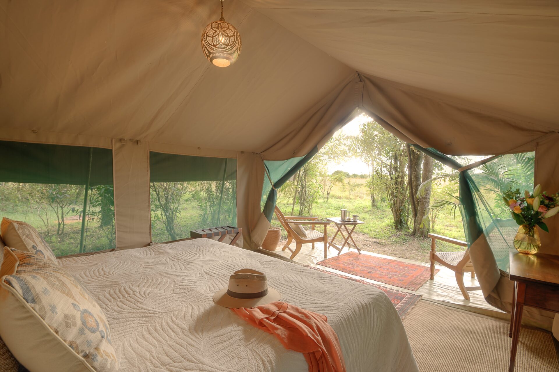 Seringet Mara Camp lit at dusk, canvas tents under acacia trees